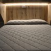 Letto matrimoniale con coperta trapuntata.