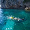 Persona fa snorkeling in mare limpido.