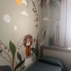 Camera con letto singolo, decorata con immagini di animali e piante stilizzate.