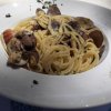 Piatto di spaghetti alle vongole con prezzemolo su un tavolo.