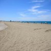 Spiaggia ampia e sabbiosa con mare blu.