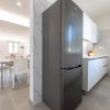 Cucina moderna con frigo nero e piano cottura bianco.