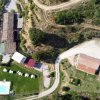 Vista aerea di un complesso con piscina, edifici e strade sterrate.