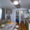 Interno di una piccola casa con cucina, tavolo e accessori da viaggio.