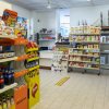 Interno di un minimarket con scaffali pieni di snack e bevande.