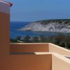 Un balcone con vista sul mare e una collina rocciosa.