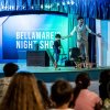 Uomo sul palco con bambino, spettacolo serale.