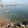 Una piccola baia con acqua cristallina e rocce lungo la riva.