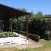 Terrazza coperta accanto a un giardino curato.