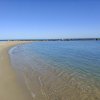 Spiaggia con mare calmo e cielo sereno.