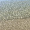 Acqua trasparente si infrange sulla sabbia.