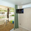 Interno con veranda, tavolo da pranzo, televisione e aria condizionata.
