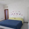 Camera da letto con letto matrimoniale e fiori sul muro.
