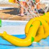 Struttura gialla a forma di serpente in un parco acquatico spruzza acqua.