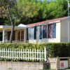 Casa prefabbricata con recinzione bianca e verde all'aperto.