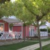 Case mobili rosse con terrazza e giardini alberati.