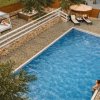 Piscina circondata da sdraio e ombrelloni.