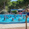Un gruppo di persone in una piscina seguendo un istruttore.