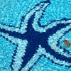 Due persone nuotano in una piscina con una decorazione a forma di stella marina blu.