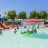 Piscina per bambini con scivoli colorati e giochi d'acqua.