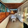 Una terrazza coperta con tavolo bianco e sedie di plastica, recintata in legno.