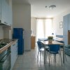 Interno appartamento con cucina blu, tavolo e divano-letto a fantasia.