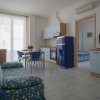 Soggiorno con cucina, divano blu a fiori gialli.