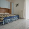 Camera con letto matrimoniale, copriletto a motivi geometrici.
