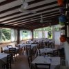 Interno di un ristorante con tavoli apparecchiati e vetrate luminose.