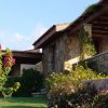 Casa in pietra con fiori e pergolato.