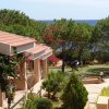 Case vista mare con giardino e alberi.
