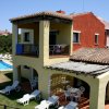 Casa con portico e piscina, lettini bianchi.