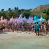 Festa in spiaggia con polveri colorate lanciate in aria.