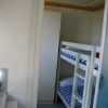 Letto a castello con lenzuola a righe blu e bianche in una piccola stanza.