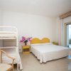 Camera con vista mare, letto matrimoniale, letto a castello, e arredo giallo.