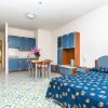 Monolocale con letto, cucina blu e tavolo.