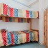 Stanza con letto a castello e coperte a righe multicolori.