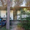 Bici parcheggiate davanti a una casa mobile in un campeggio alberato.