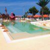Piscina con scivolo, palme e decorazioni di tartarughe.