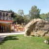 Entrata villaggio camping con insegna su roccia.