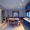 Interno di una cucina con tavolo da pranzo e sedie, mobili blu.
