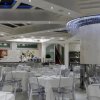 Ristorante elegante con tavoli bianchi e lampadario moderno.