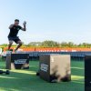 Persona che esegue esercizi di salto su scatole in un campo all'aperto.