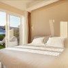 Camera da letto luminosa con un letto matrimoniale e porta finestra che si apre su un giardino.